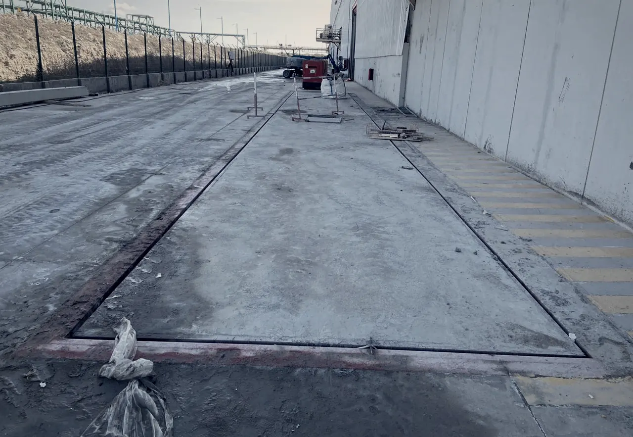 Pont-bascule encastré en fosse, affleurant la dalle béton d'un site industriel