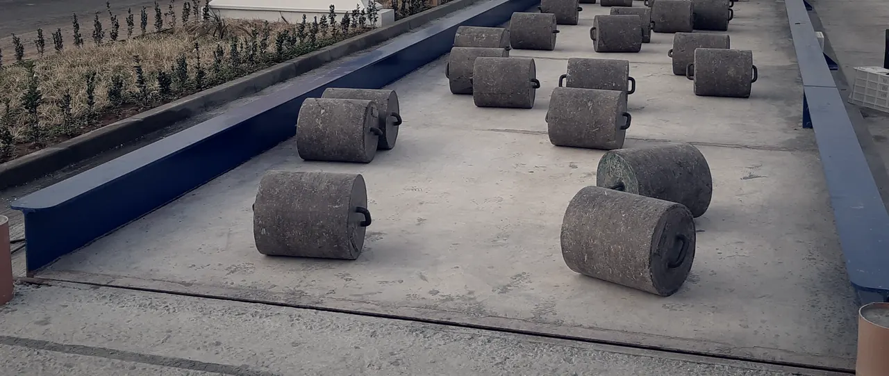 Vérification d'un pont-bascule : masses étalons disposées sur toute la longueur du tablier